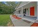 Close-up of a home's front porch with white columns, a red door, and freshly laid mulch at 3290 Ebenezer Se Rd, Conyers, GA 30094