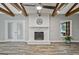 Inviting living room with painted brick fireplace, wood flooring, and timber-beam ceiling accents at 3290 Ebenezer Se Rd, Conyers, GA 30094
