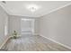 Spacious living room with gray walls, decorative molding, light fixture, and stylish gray wood flooring at 3290 Ebenezer Se Rd, Conyers, GA 30094
