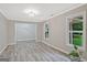 Bright and airy living room featuring gray wood-look floors and large windows overlooking the landscaped yard at 3290 Ebenezer Se Rd, Conyers, GA 30094