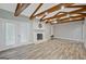 Inviting living room with painted brick fireplace, wood flooring, and timber-beam ceiling accents at 3290 Ebenezer Se Rd, Conyers, GA 30094