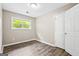 Neutral bedroom featuring wood-look flooring, window, and a white door at 5724 Amalfi Way, Douglasville, GA 30135