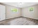 Bright bedroom with laminate flooring and two windows at 5724 Amalfi Way, Douglasville, GA 30135