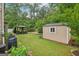An inviting backyard showing a gazebo seating area and storage shed among mature trees at 12323 Styron Dr, Hampton, GA 30228