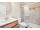 Tiled bathroom with glass door shower, toilet, and modern sink with a round mirror above at 12323 Styron Dr, Hampton, GA 30228