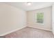 A bright bedroom features neutral carpeting, window with blinds, and fresh white trim at 12323 Styron Dr, Hampton, GA 30228