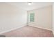 Empty bedroom features neutral carpeting, window with blinds, and fresh white trim at 12323 Styron Dr, Hampton, GA 30228