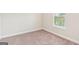 Empty bedroom features neutral carpeting, window with blinds, and fresh white trim at 12323 Styron Dr, Hampton, GA 30228