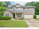 Charming two-story brick home featuring a well-maintained lawn and attached two-car garage at 12323 Styron Dr, Hampton, GA 30228
