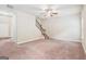 Inviting carpeted living area with a staircase, a ceiling fan, and a view of the front door at 12323 Styron Dr, Hampton, GA 30228