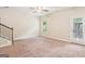 Spacious carpeted living area with a ceiling fan, a door to the outside, and staircase at 12323 Styron Dr, Hampton, GA 30228
