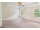 Bedroom showcasing carpeted floors, a ceiling fan, and natural light from two windows at 12323 Styron Dr, Hampton, GA 30228