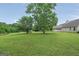Large backyard with mature trees surrounding the manicured lawn at 130 Belmont Trl, Covington, GA 30016