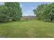 Expansive backyard, featuring a well-manicured lawn with mature trees surrounding the property at 130 Belmont Trl, Covington, GA 30016