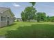 Spacious backyard with a lush green lawn and mature trees near a screened in porch at 130 Belmont Trl, Covington, GA 30016