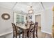 Dining room with wood table and chairs beneath a modern chandelier, next to a window at 130 Belmont Trl, Covington, GA 30016