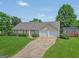Well-maintained single-story home with a large driveway, two-car garage, and storage shed at 130 Belmont Trl, Covington, GA 30016