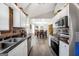Bright kitchen with white cabinetry, stainless steel appliances, and modern countertops with a dining area in the background at 130 Belmont Trl, Covington, GA 30016