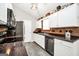 Well-lit kitchen with white cabinets, stainless steel appliances, and modern countertops with wood-look flooring at 130 Belmont Trl, Covington, GA 30016