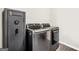 Modern laundry room with stainless steel washer and dryer and a gun safe at 130 Belmont Trl, Covington, GA 30016