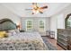 Bright main bedroom featuring two windows, a trey ceiling, a ceiling fan, hardwood floors, and well-appointed furnishings at 130 Belmont Trl, Covington, GA 30016