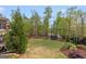 Expansive backyard features a lush lawn, mature trees, colorful landscaping, and trampoline at 157 Waterlace Way, Fayetteville, GA 30215