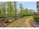 Wide shot of backyard with mature trees, landscaping, and access to the lake at 157 Waterlace Way, Fayetteville, GA 30215