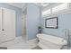 Relaxing bathroom featuring a standalone tub, glass-enclosed shower, and tranquil blue walls at 157 Waterlace Way, Fayetteville, GA 30215