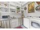 Bright laundry room with sink, ample shelving, modern appliances, and stylish decor at 157 Waterlace Way, Fayetteville, GA 30215