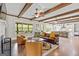 Bright living room showcasing wood floors, ceiling beams, and a view of the outdoors at 157 Waterlace Way, Fayetteville, GA 30215