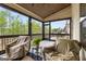 Screened porch features a wood ceiling, covered furniture, and serene views of the surrounding greenery at 157 Waterlace Way, Fayetteville, GA 30215