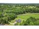Aerial view reveals brick house on an expansive lot surrounded by lush greenery in a tranquil rural setting at 3950 Chattahoochee Rd, Cumming, GA 30041