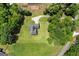Aerial view of brick home with circular driveway nestled amongst lush greenery, offering privacy and curb appeal at 3950 Chattahoochee Rd, Cumming, GA 30041