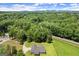 Aerial view showcasing home surrounded by abundant trees, emphasizing its peaceful and private setting near a road at 3950 Chattahoochee Rd, Cumming, GA 30041