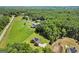 An aerial view showing a brick home on a sprawling lot, barn and bordered by lush greenery, perfect for country living at 3950 Chattahoochee Rd, Cumming, GA 30041