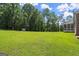 Expansive backyard with lush green lawn and mature trees, perfect for outdoor activities at 3950 Chattahoochee Rd, Cumming, GA 30041