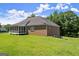 Backyard view showcasing home's brick exterior, screened porch and generous green lawn at 3950 Chattahoochee Rd, Cumming, GA 30041