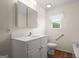 Bright bathroom with white vanity, mirrored cabinet, and window at 3950 Chattahoochee Rd, Cumming, GA 30041