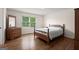 Bedroom featuring wood floors, a wooden bed, and a window with natural light at 3950 Chattahoochee Rd, Cumming, GA 30041