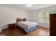 Bright bedroom with hardwood floors, a comfortable bed, and natural light from the window at 3950 Chattahoochee Rd, Cumming, GA 30041