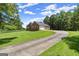 Long driveway leading to a beautiful brick home with a well-manicured lawn at 3950 Chattahoochee Rd, Cumming, GA 30041