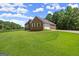 Brick home featuring an attached garage and a vast green lawn surrounded by mature trees at 3950 Chattahoochee Rd, Cumming, GA 30041