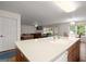 Kitchen with a white countertop island overlooking a cozy living space with a fireplace at 3950 Chattahoochee Rd, Cumming, GA 30041