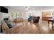 Open-concept living room with hardwood floors, fireplace, and access to kitchen and dining at 3950 Chattahoochee Rd, Cumming, GA 30041