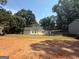 Bright home features a lush backyard, surrounded by mature trees, on a sunny day at 5431 S Lake Dr, Douglasville, GA 30135