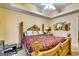 Spacious bedroom with tray ceilings, a decorative headboard, and an ensuite bathroom at 1214 Greenridge Ln, Lithonia, GA 30058