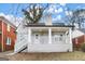 Charming grey brick home featuring a covered front porch with white railings and supporting columns at 1030 Westmoor Nw Dr, Atlanta, GA 30314