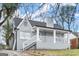 Angle view of the grey brick home highlighting the covered porch and stairs leading to the front door at 1030 Westmoor Nw Dr, Atlanta, GA 30314