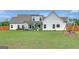 Back exterior view of home with lush green yard and a covered back porch with ample space for seating at 17 Sawtooth Oak Dr, Moreland, GA 30259
