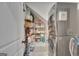 Functional laundry room with shelving for storage and stacked washer and dryer at 17 Sawtooth Oak Dr, Moreland, GA 30259